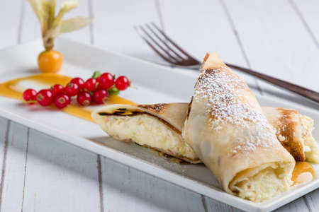 european pancakes, sweet crepe with topping on white long plateの写真素材