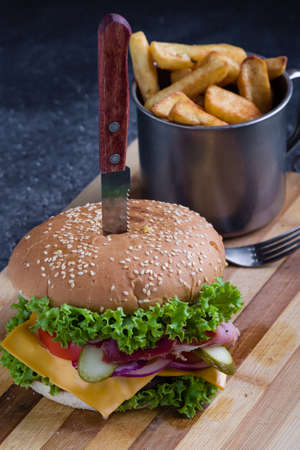 tasty rustic hamburger with fries on wooden tableの写真素材