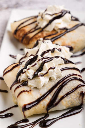 european pancakes, sweet crepe with topping on white long plateの写真素材