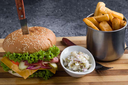 tasty rustic hamburger with fries on wooden tableの写真素材