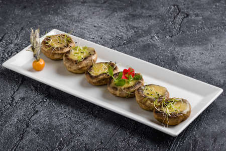 grilled mushroom stuffed with cheese on white plateの写真素材