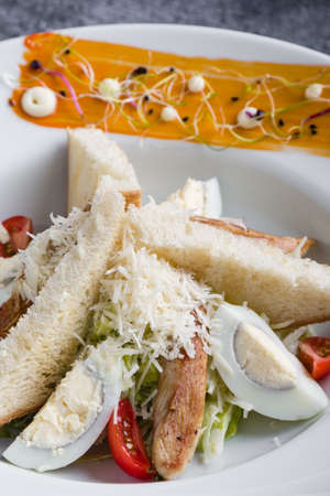 fresh tasty caesar salad appetizer in white plateの写真素材