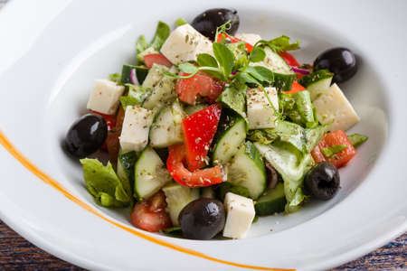 fresh tasty greek salad appetizer on white plateの写真素材