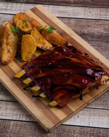 grilled pork ribs with potato on wooden tableの写真素材