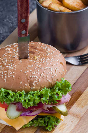 tasty rustic hamburger with fries on wooden tableの写真素材