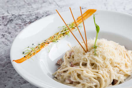 italian spahetti carbonara pasta in white plateの写真素材