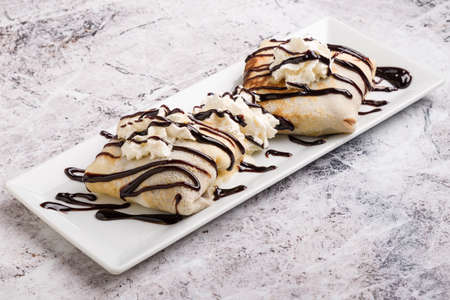 european pancakes, sweet crepe with topping on white long plateの写真素材