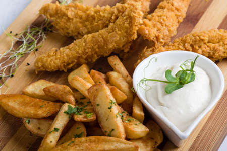 deep fried crispy chicken with fries and dipping sauceの写真素材