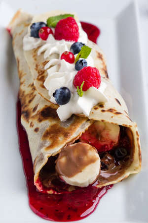 european pancakes, sweet crepe with topping on white long plateの写真素材