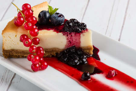 fresh tasty cheese cake with fruits on white plateの写真素材