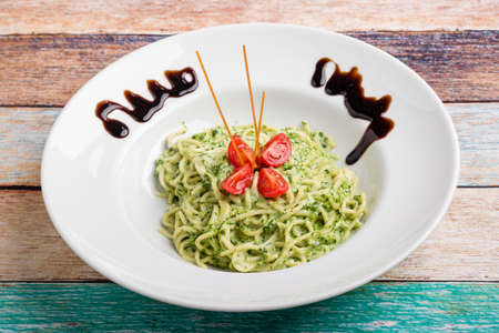 tasty spinach with spaghetti pasta on white plateの写真素材