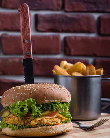 tasty rustic hamburger with fries on wooden tableの写真素材