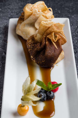 european pancakes, sweet crepe with topping on white long plateの写真素材