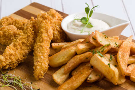 deep fried crispy chicken with fries and dipping sauceの写真素材