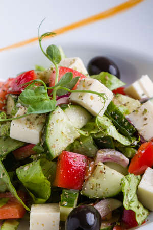 fresh tasty greek salad appetizer on white plateの写真素材