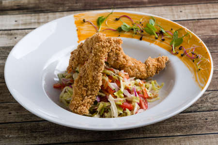 tasty crispy chicken salad appetizer in white plateの写真素材