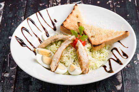 fresh tasty caesar salad appetizer in white plateの写真素材