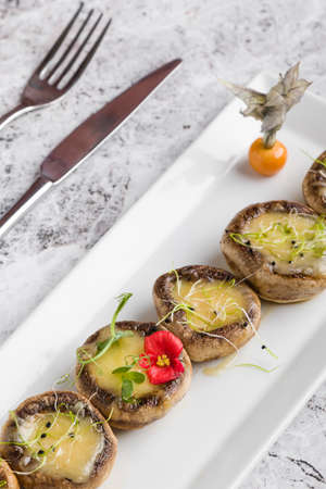 grilled mushroom stuffed with cheese on white plateの写真素材