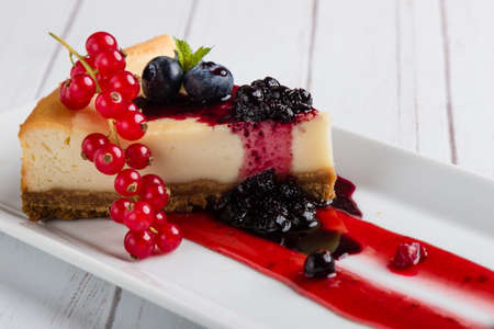 fresh tasty cheese cake with fruits on white plateの写真素材