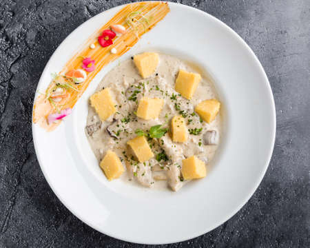 chicken with mushrooms sauce and polenta cubes in white tableの写真素材