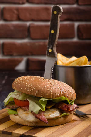 tasty rustic hamburger with fries on wooden tableの写真素材