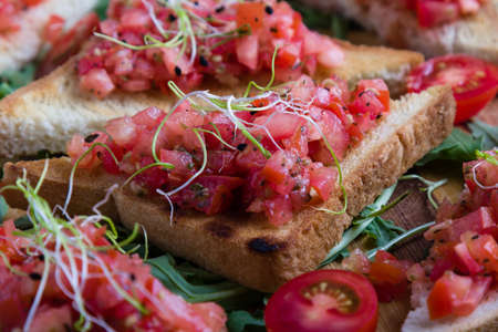 bruschetta with tomato basil and rucola on wooden boardの写真素材