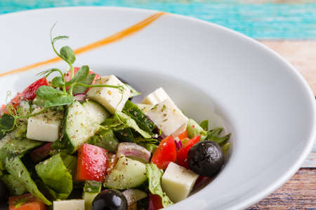 fresh tasty greek salad appetizer on white plateの写真素材