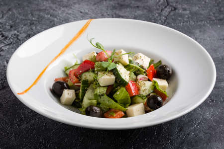 fresh tasty greek salad appetizer on white plateの写真素材