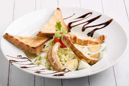 fresh tasty caesar salad appetizer in white plateの写真素材