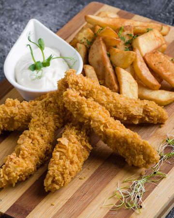 deep fried crispy chicken with fries and dipping sauceの写真素材
