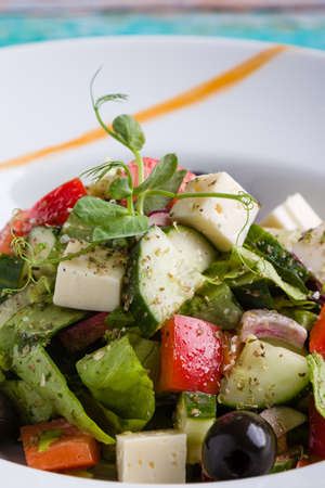 fresh tasty greek salad appetizer on white plateの写真素材
