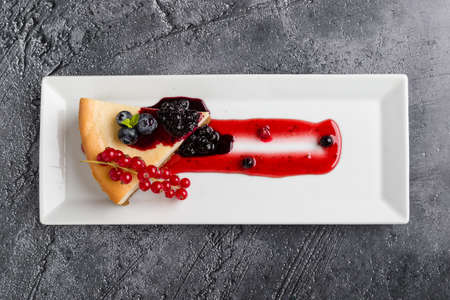 fresh tasty cheese cake with fruits on white plateの写真素材