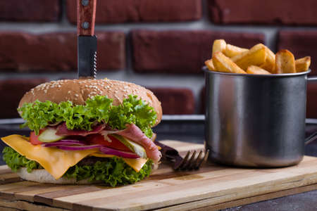 tasty rustic hamburger with fries on wooden tableの写真素材