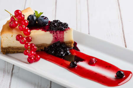 fresh tasty cheese cake with fruits on white plateの写真素材
