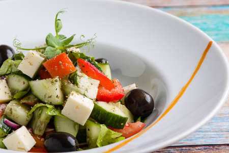 fresh tasty greek salad appetizer on white plateの写真素材
