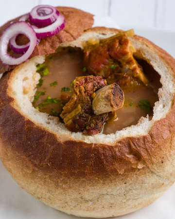 tasty delicious bean soup with smoked meat in breadの写真素材