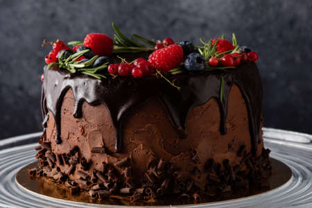 chocolate cake dessert with brown icing and fruits in rustic styleの写真素材