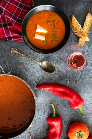 Rustic tomato soup with white cheese in black bowlの写真素材