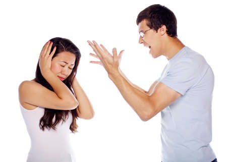 Young woman covering ears from shouting boyfriend on isolated white backgroundの写真素材