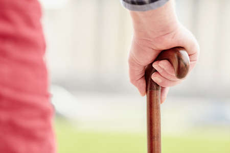 Close up of walking stick in senior male hand outdoors - recovery conceptの写真素材
