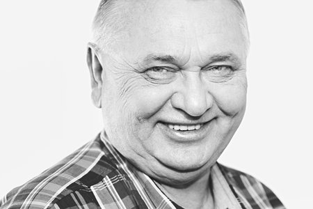 Close up black and white portrait of laughing aged man - retirement concept