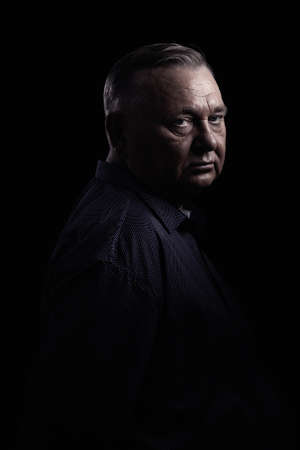 Classic portrait of aged man wearing shirt against black background - retirement conceptの写真素材