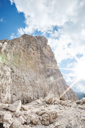 Female rock climber abseiling off climb during summer sunny day in Dolomite Alps, Cinque Torri, Italy - mountaineering, sport climbing or adventure conceptの写真素材