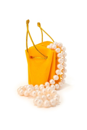 Yellow gift bag with a string of pearls on a white backgroundの写真素材