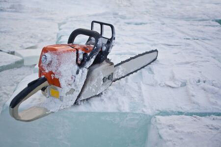 Chainsaw lying in the snowの写真素材
