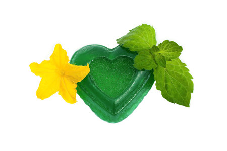 Green soap with mint leaves and yellow flower on a white backgroundの写真素材