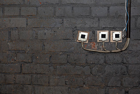  Old brick wall with electrical switches in dark colorsの写真素材