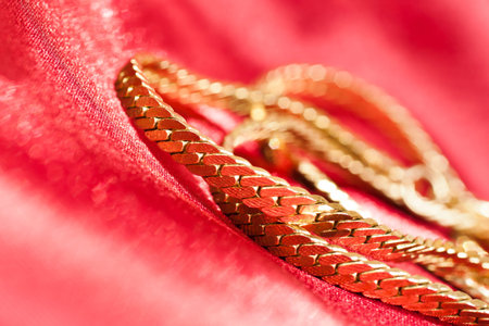 Gold chain on red cloth closeup
