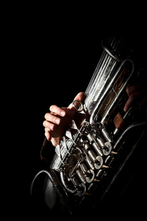Hand of the person playing the tuba in dark colors の写真素材