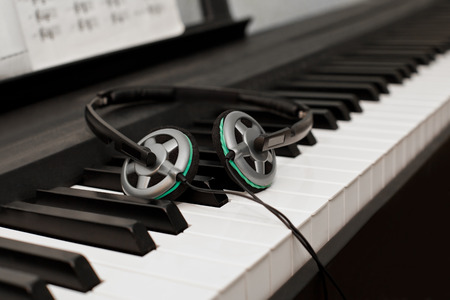 Headphones lying on the piano keysの写真素材